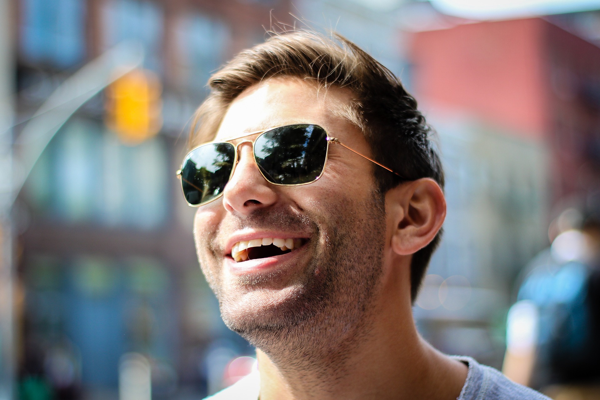 Lachender Mann mit Sonnenbrille als Sinnbild wie man selbstbewusst führen kann