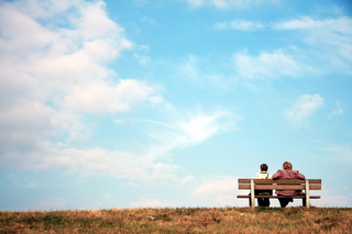 Zwei Menschen auf einer Bank am Horizont als Sinnbild für die Freundschaft mit dem inneren Kritiker
