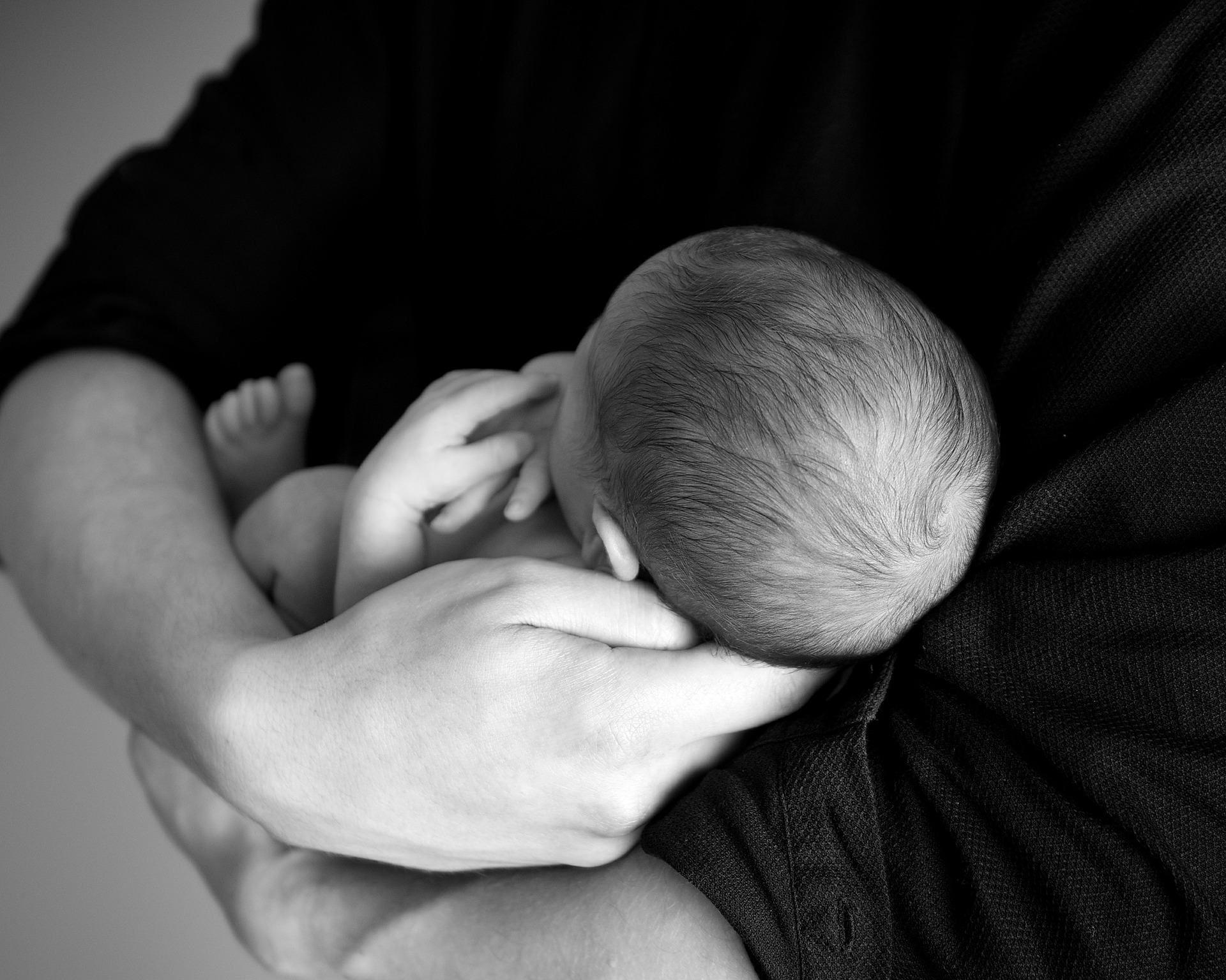 Baby im Arm seines Vaters als Symbol für das innere Kind