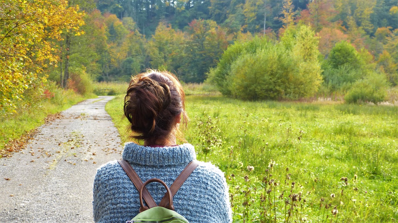 Frau auf einem Wanderweg mit Rucksack als Sinnbild für Veränderung